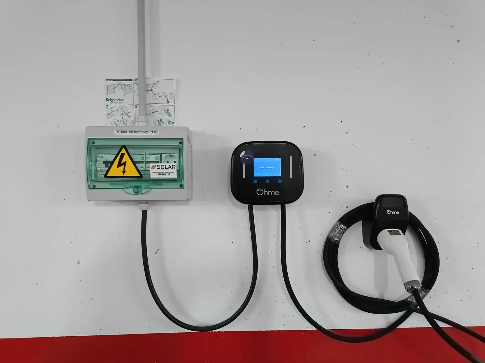 Cargador Ohme Home Pro con cuadro de protecciones en un garaje