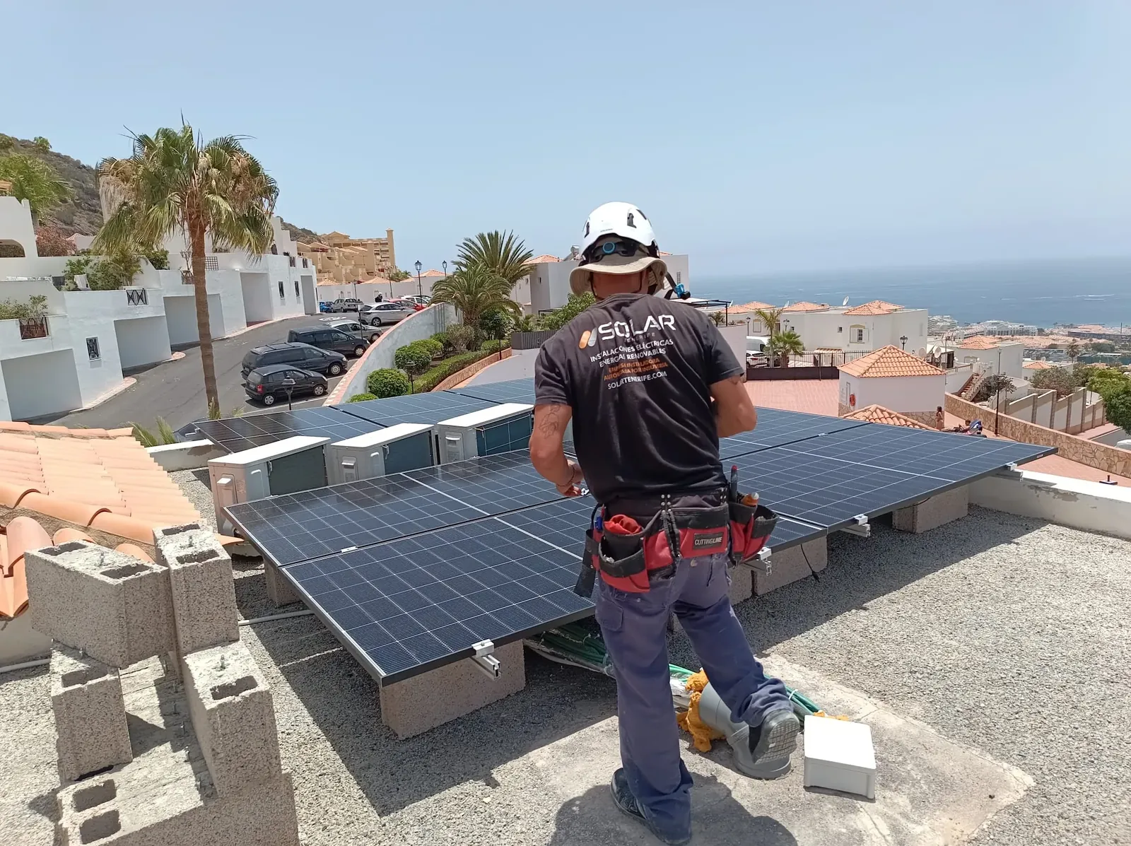 Técnico de Solar Tenerife trabajando junto a paneles fotovoltaicos