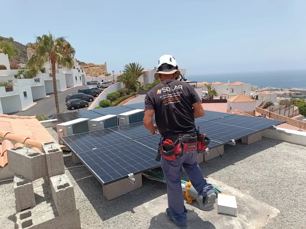Técnico de Solar Tenerife trabajando junto a paneles fotovoltaicos
